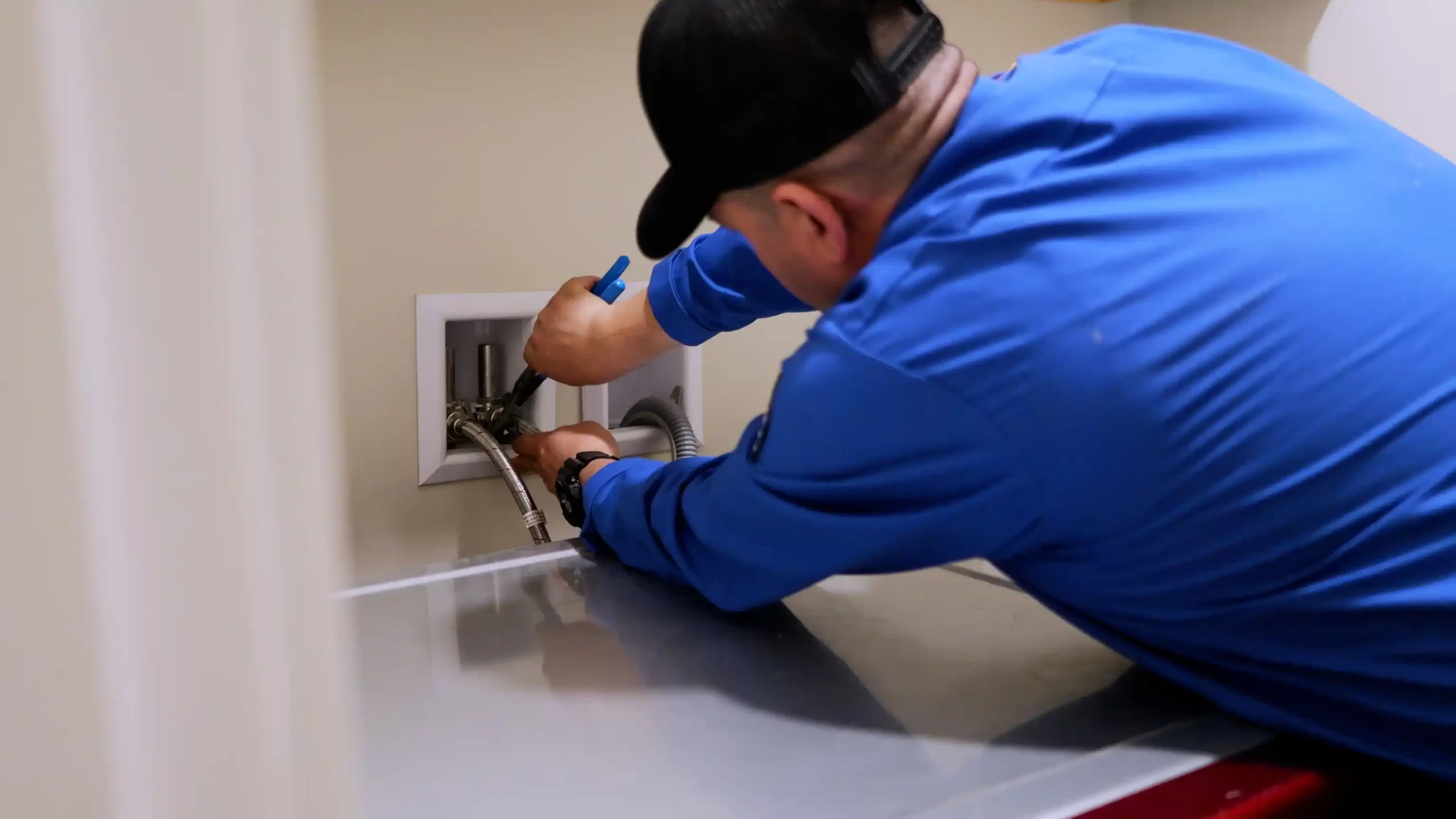 a man in a blue shirt working on a pipe